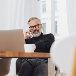 Man smiling while working on laptop