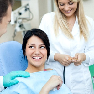 A young female patient talking with her dentist and dental assistant