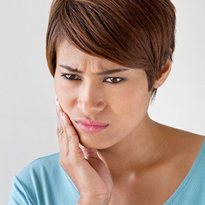 Woman holding cheek in pain