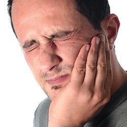 Man holding jaw in pain