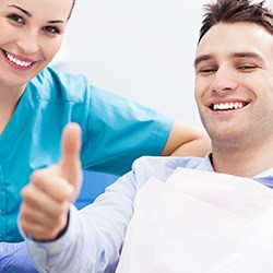 Man in dental chair giving thumbs up