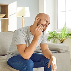 a person holding their face due to a toothache