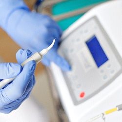 An up-close view of a dental professional preparing to use a soft tissue laser