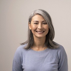 Older woman in grey shirt smiling