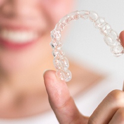 Closeup of patient holding Invisalign in Homer Glen