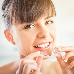 Woman placing her Invisalign tray