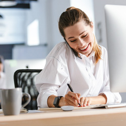 Woman smiling while taking notes on phone