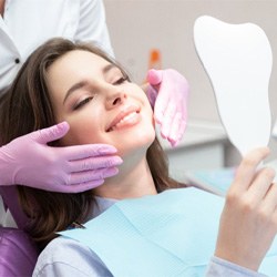 : A woman admiring the results of her smile makeover