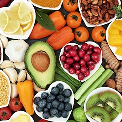Bird’s eye view of various fruits and veggies in white heart bowls