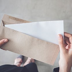 Hands holding a letter in cardboard envelope