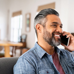Man smiling while talking on phone at home