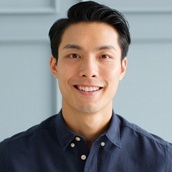 Man standing in front of a house and smiling