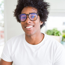 Young man with glasses sitting and smiling