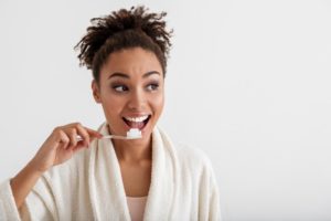 Woman looking away from camera brushing her teeth