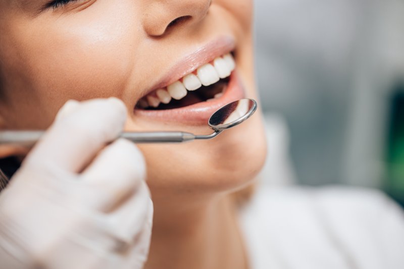 Cosmetic dentist examining a woman’s smile