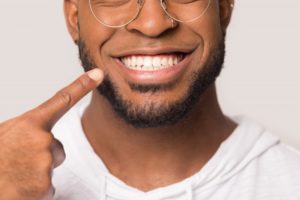patient pointing to their smile after getting a dental crown