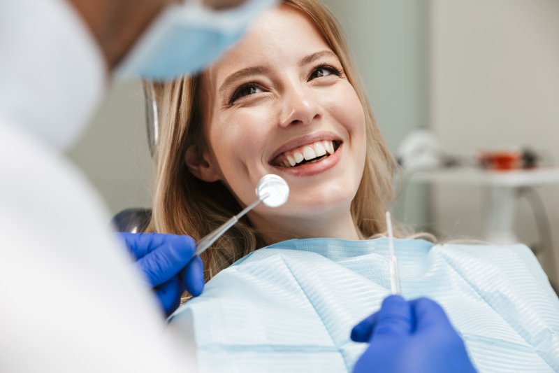 A woman smiling while talking to her dentist about her oral health condition