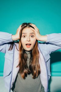 Frightened woman with her hands on her head