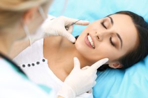 Dentist examining woman’s smile