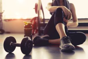 Woman at the gym with weight and water bottle