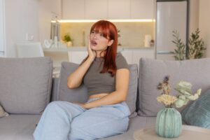 Woman wearing concerned expression as she touches her face 