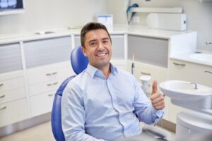 Man smiling and holding a thumbs up