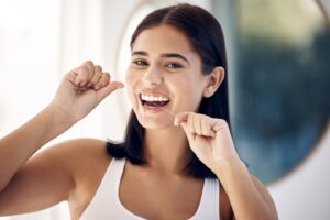 Woman flossing with dental floss.
